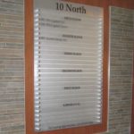 Interior brushed aluminum directory sign with frosted acrylic slats, vinyl graphics and brushed aluminum standoffs